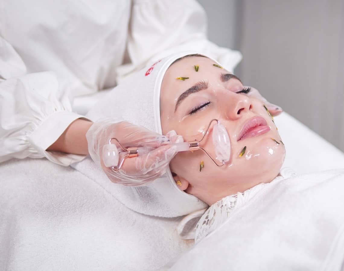 a woman getting a facial mask on her face